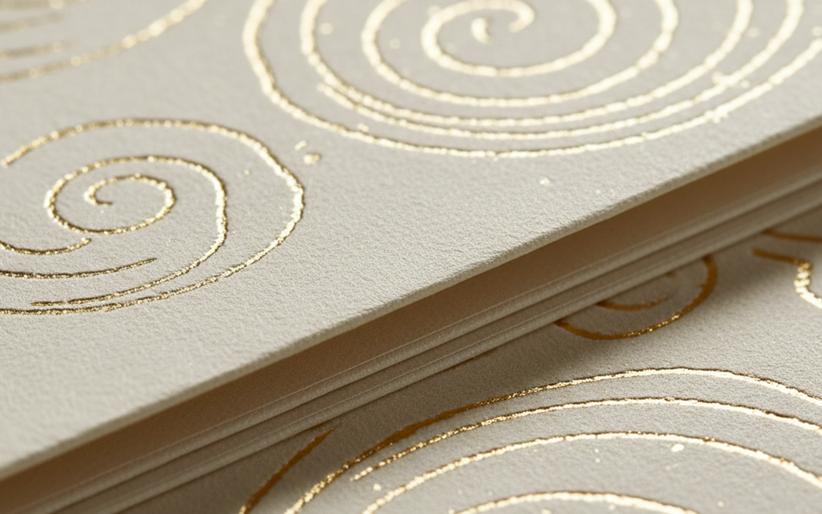 Gros plan sur finitions dorées premium avec motifs circulaires sur cartes de vœux haut de gamme